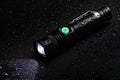 Flashlight water resistant in drops on black background Royalty Free Stock Photo