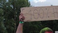 Flashmob participant with hands up in air holding free hugs sign, having fun