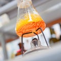 Flask with orange liquid boiling in lab