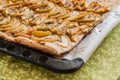 Flat apple pie on a baking sheet