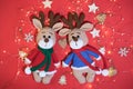 Flat background on Valentines day or new year. Two adorable hand knitted amigurumi reindeer in red and blue sweater and scarves on