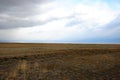 Flat and boundless steppe under the autumn cloudy sky Royalty Free Stock Photo