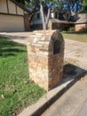 Flat brown stone mail box in green yard