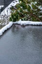 Flat carport roof covered in snow, slush, ice, and water, with clogged downspout drain Royalty Free Stock Photo