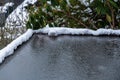 Flat carport roof covered in snow, slush, ice, and water, with clogged downspout drain Royalty Free Stock Photo