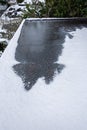 Flat carport roof covered in snow, slush, ice, and water, with clogged downspout drain Royalty Free Stock Photo