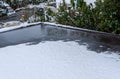 Flat carport roof covered in snow, slush, ice, and water, with clogged downspout drain, residential neighborhood Royalty Free Stock Photo