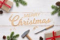 Flat Christmas greeting with carved text into white wooden surface with chisel and hammer Royalty Free Stock Photo