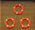 Flat closeup of three red lifebuoys wall on white