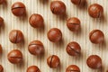 Flat composition with Australian macadamia nuts on bamboo light background. Patterns, repetitions