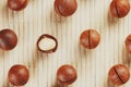 Flat composition with Australian macadamia nuts on bamboo light background. Patterns, repetitions