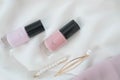 A flat composition of nail polish and golden female hairpins decorated with pearls. Modern and fashion spring or summer