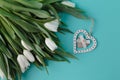 Flat frame from white tulips on plain aquamarine background