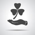 Flat hand presenting Clover with three leaves sign icon. on a g