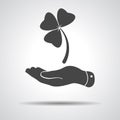 Flat hand presenting Clover with three leaves sign icon. on a g