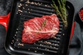 Flat iron steak on a grill pan, raw meat, marbled beef . Black background. Top view Royalty Free Stock Photo