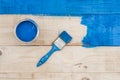 Flat lay above bucket with blue paint and brush on the wooden board Royalty Free Stock Photo