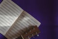 Flat lay acoustic guitar fingerboard head and an open music notebook on a blue background Royalty Free Stock Photo