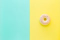 Flat lay antistress toy squish in form of pink donut with sprinkles. Bright yellow blue background. Compressing, soft, squeezable