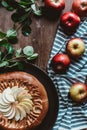 flat lay with arranged homemade apple pie, fresh apples with green leaves and linen Royalty Free Stock Photo