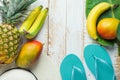 Flat Lay Arrangement Composition Tropical Fruits Pineapple Mango Bananas Green Palm Leaf Women Hat Blue Slippers on White Wood Royalty Free Stock Photo