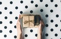 Flat lay arrangement female`s hands holding gift boxes on white polka dots background