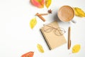Flat lay autumn composition with cup of hot chocolate, paper notebook, fashion women glasses, cinnamon sticks, fallen leaves on