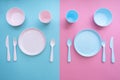 Flat lay baby feeding set. Sippy cup, plate, bowl, cutlery on pastel pink and blue background. Royalty Free Stock Photo