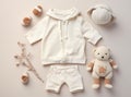 Flat lay of a baby's outfit and accessories, including a hoodie, shorts, socks, and a teddy bear, on a light pink Royalty Free Stock Photo