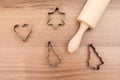 Flat lay of baking equipment like wooden rolling pin and baking molder knife on a wooden table