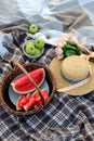 Flat-lay of basket with slices of watermelon, a bowl with green apples, a bouquet of pink roses, a straw hat, a top view. Royalty Free Stock Photo