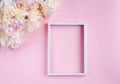 Flat lay with beautiful bouquet of cream peonys and white vertical frame on pink background. Close up. Top view. Copy space