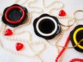 Flat lay. A beautiful composition of glass black dishes, plastic jewelry, bracelets, beads, red hearts on a white background. Royalty Free Stock Photo