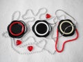 Flat lay. A beautiful composition of glass black dishes, plastic jewelry, bracelets, beads, red hearts on a white background. Royalty Free Stock Photo