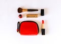 Flat lay of beauty cosmetic make up products in red, black and gold color knolled on white background. Royalty Free Stock Photo