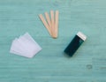 Beauty, waxing set for epilation of different means wax cartridge with spatula, fabric strips on wood and blue background. Tools f