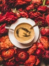 Black espresso coffee in cup on red ranunculus flower background Royalty Free Stock Photo