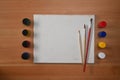 Flat lay blank canvas, watercolors and paint brushes on wooden background. Artist or designer workplace Royalty Free Stock Photo