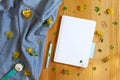 Flat lay of blank notepad, a pen, a watch and yellow barberry flowers