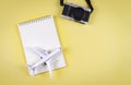 flat lay of blank page opened notebook, airplane model and camera on yellow background with copy space. Travel, photo and memory Royalty Free Stock Photo