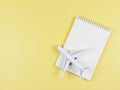 flat lay of blank page opened notebook, airplane model on yellow background with copy space. Travel planning concept Royalty Free Stock Photo