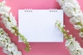 Flat lay of blank paper desk spiral calendar decorate with white flower isolated on pink background.