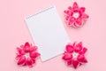 Flat lay of blank paper desk spiral note decorate with pink flowers on light pink background Royalty Free Stock Photo