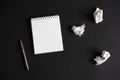 Flat lay of blank white notepad, pencil and crumpled paper on black background Royalty Free Stock Photo