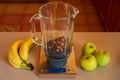 flat-lay of a blender on a kitchen digital scale with blueberries and nuts, and around bananas and apples Royalty Free Stock Photo