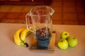 flat-lay of a blender on a kitchen digital scale with blueberries and nuts, and around bananas and apples Royalty Free Stock Photo