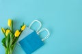 Flat lay blue background with flowers and paper bags Royalty Free Stock Photo