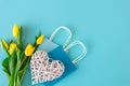 Flat lay blue background with flowers and paper bags. Royalty Free Stock Photo
