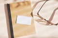 Flat lay of branding identity business name card on notebook with eyeglasses, light and shadow shape leaves