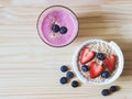 Flat lay of  breakfast with oat or granola in white bowl, fresh blueberries, strawberries, a  glass of blueberry smoothie  on Royalty Free Stock Photo